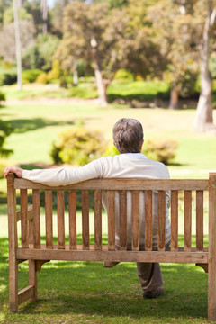 男子坐在公园里的长椅上