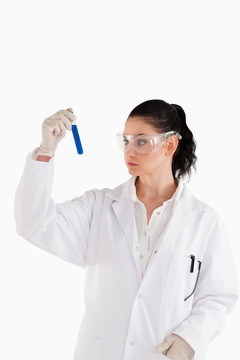 实验室里看试管的黑发女科学家