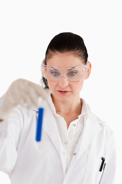 实验室里看试管的黑发女科学家