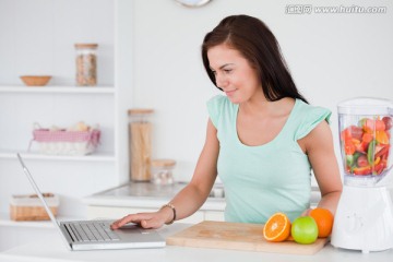 边榨果汁边用电脑的女人