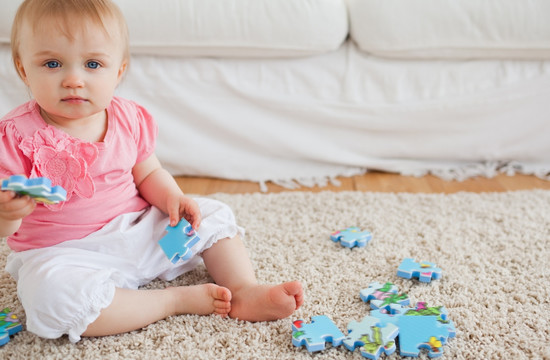 婴儿坐在地毯上玩拼图游戏