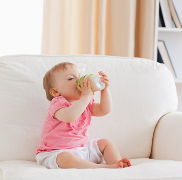在沙发上用奶瓶喝奶的小宝宝