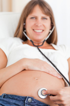 用听诊器听肚子的孕妇