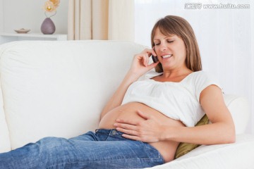 在沙发上打电话的孕妇