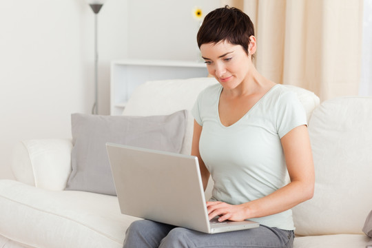 女人坐在沙发上玩电脑
