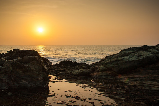 夕阳下的海边礁石