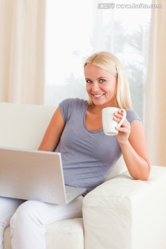 边喝咖啡边使用电脑的女人