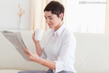沙发上喝咖啡看报的女人