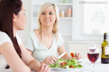 在餐桌上吃沙拉的女人