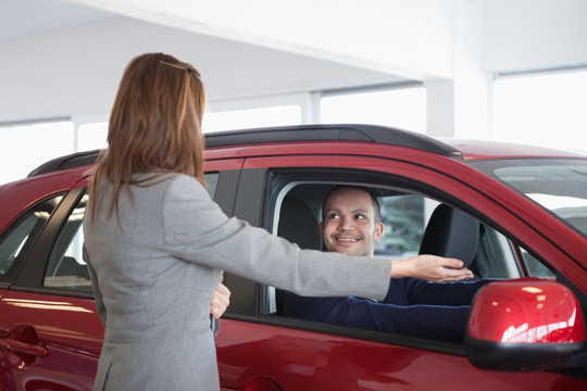 汽车导购员为体验汽车的顾客说明