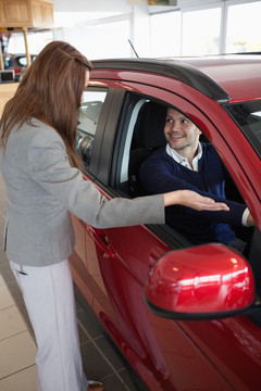 汽车导购员为体验汽车的顾客说明