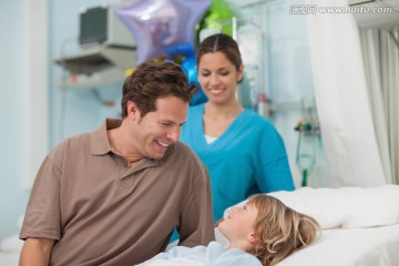 护士和父亲陪着病床上的小男孩