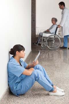 护士坐在地上用平板电脑