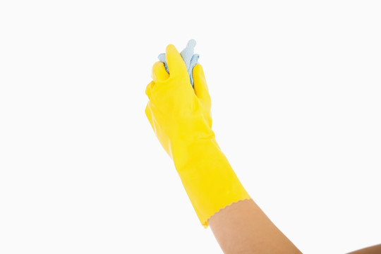 戴着黄色手套的手拿着抹布