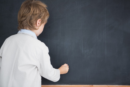 打扮成老师在黑板上写字的小男孩