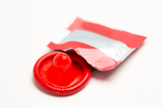 拆开包装的红色避孕套