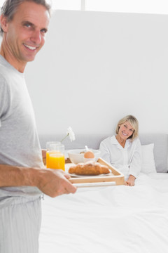 男人把早餐端给床上的妻子