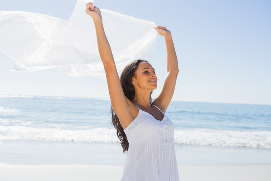 女人在沙滩上拿着纱笼