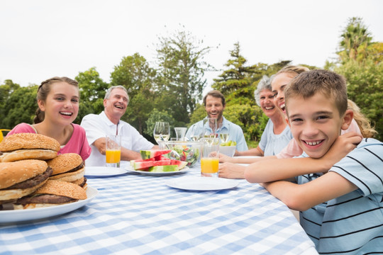 家庭在户外野餐桌上微笑