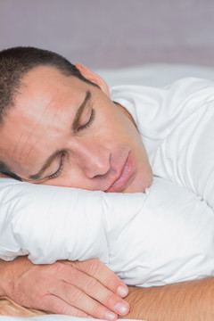 男人抱着枕头在睡觉 