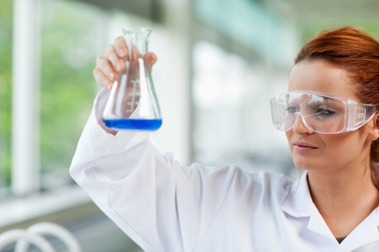 女科学家在看锥形瓶里的蓝色液体