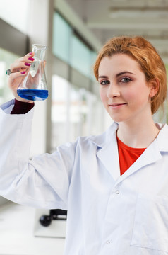 化学家在看锥形瓶里的蓝色液体