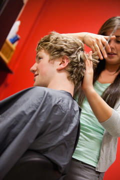 女发型师在给客人剪头发