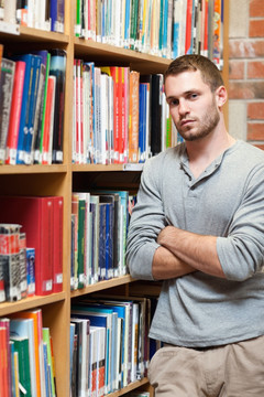在图书馆里抱着双臂的男生