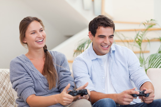 夫妇开心地在客厅里玩电子游戏