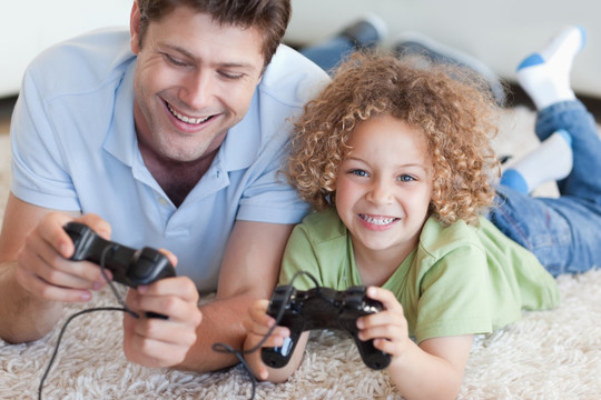 男孩和他的父亲在玩电子游戏