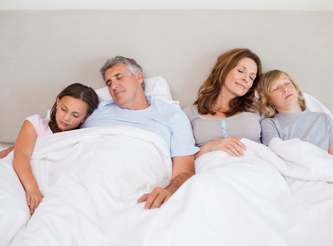 快乐的一家人躺在床上