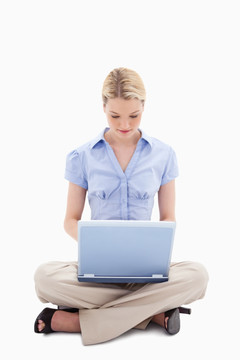 盘腿坐在地上用笔记本电脑的女人