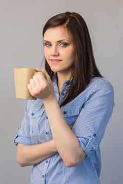 端着咖啡杯看着镜头的女人