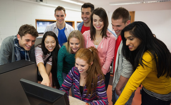 学生聚在一起看着电脑屏幕