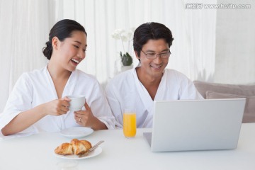 夫婦微笑著看著筆記本電腦