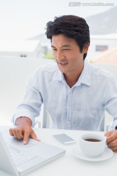 喝咖啡使用笔记本电脑的男人