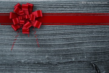 红色的圣诞丝带与灰色木板