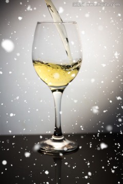 雪落在有白葡萄酒的酒杯上