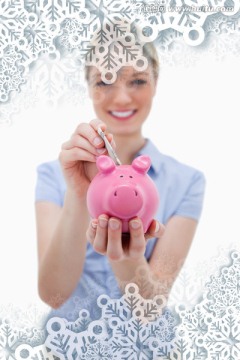 微笑着拿着小猪存钱罐的女人