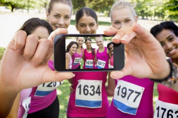 女运动员们手持智能手机自拍