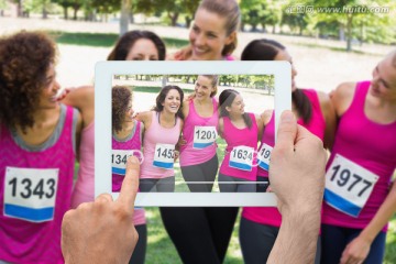 手持平板电脑给女运动员们拍照