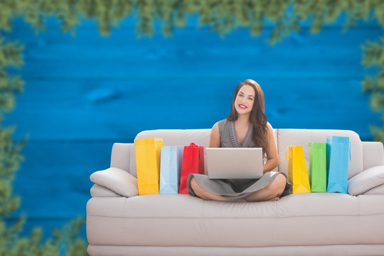 微笑女人坐着沙发上玩电脑