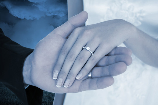 夫妇拉着戴戒指的手的复合形象