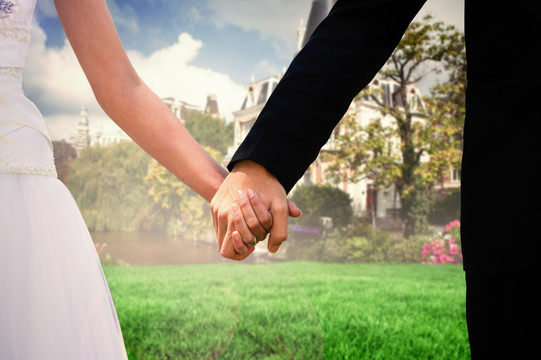 在公园里牵着手的新婚夫妇