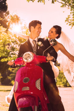 新婚夫妇坐在摩托车上的复合形象