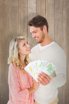 夫妇微笑着拿着纸币的复合形象