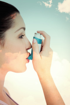 女人拿着哮喘器对着嘴