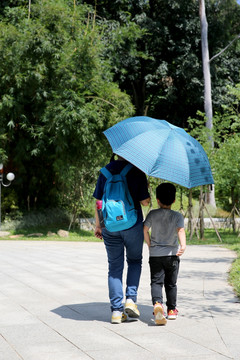撑伞的母亲与小男孩