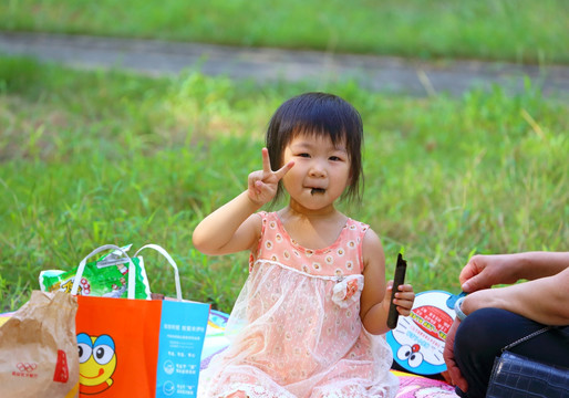 在公园吃零食的小女孩