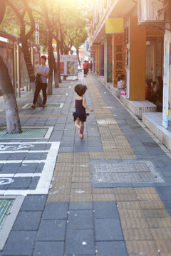 小女孩在过道人行道上奔跑而去